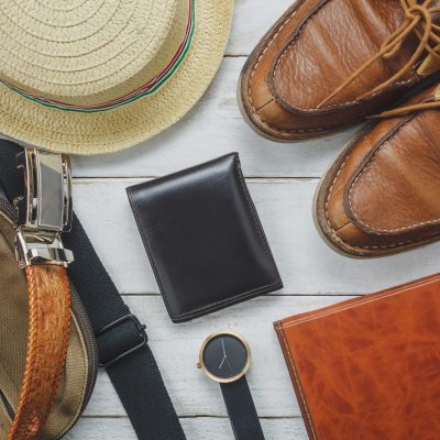 Top view accessoires to travel with man clothing concept. wallet Top view accessoires to travel with man clothing concept. wallet on wooden background.watch,bag,hat,notebook and shoe on white wood table.